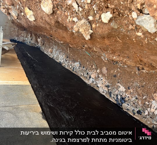 אזור אטום עם חומר שחור ליד קיר אדמה